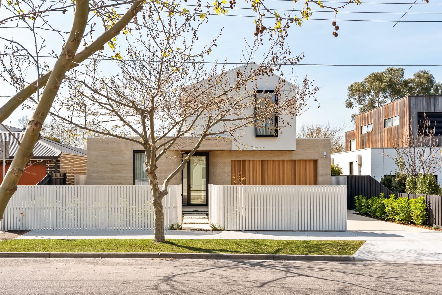 Alphington Residence — street view of the completed home behind a white slatted fence